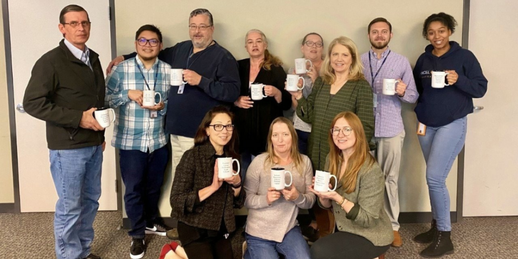 Excel Courier team holding their Strength Mugs